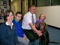 Karen, with Coco, headmaster Adam and some of the children enjoying the benefits of a school dog.
